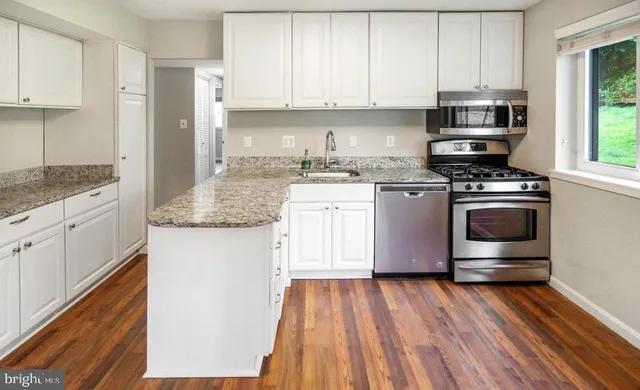 a kitchen with stainless steel appliances granite countertop a stove and a sink