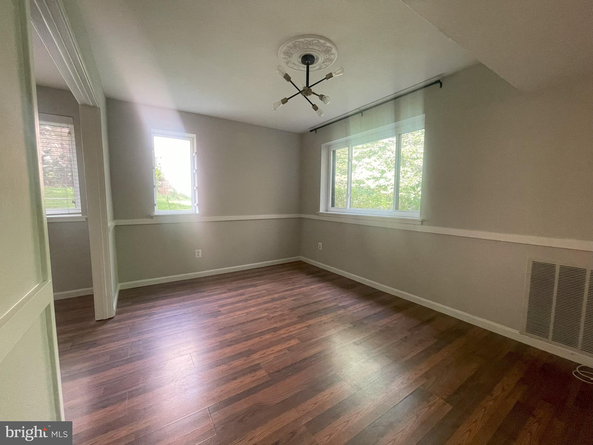 1661 Parkcrest Circle, Unit 100 Reston, VA 20190 - Photo 7 of 13 an empty room with wooden floor and windows