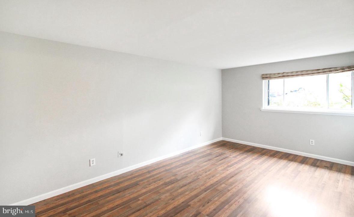 1661 Parkcrest Circle, Unit 100 Reston, VA 20190 - Photo 8 of 13 an empty room with wooden floor and windows