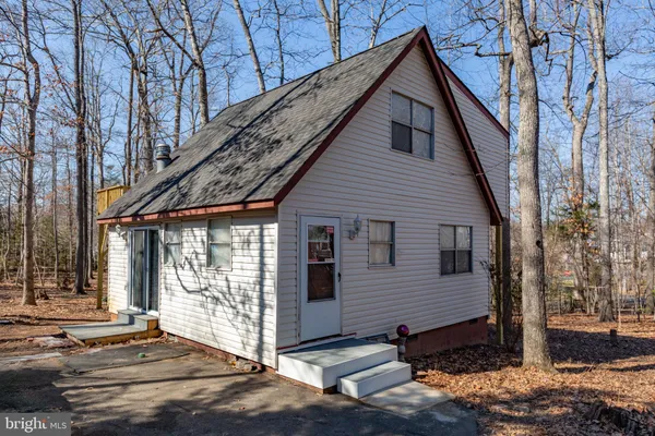 a view of a house with a small yard and wooden floor and fence