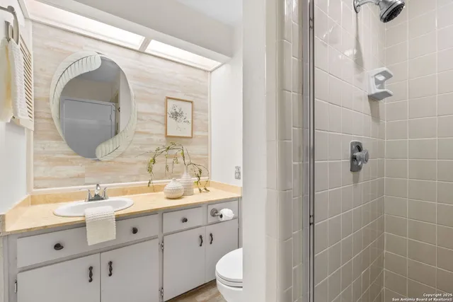 a bathroom with a double vanity sink mirror and toilet