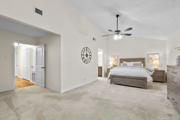 a bedroom with a large bed and a chandelier
