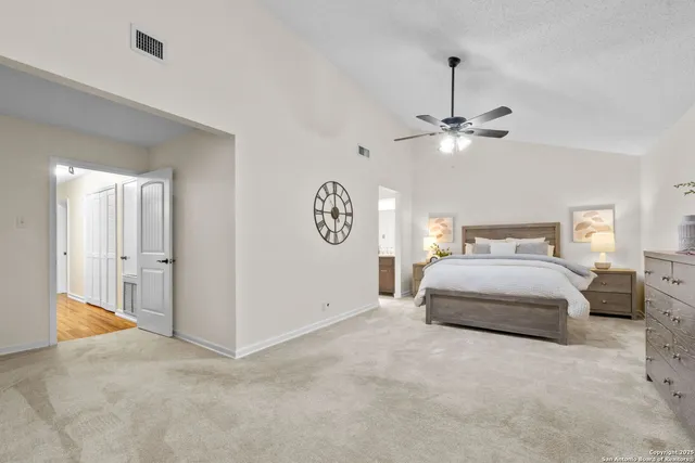 a bedroom with a large bed and a chandelier
