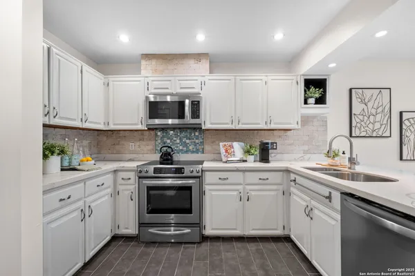 a kitchen with stainless steel appliances granite countertop a sink and cabinets with wooden floors