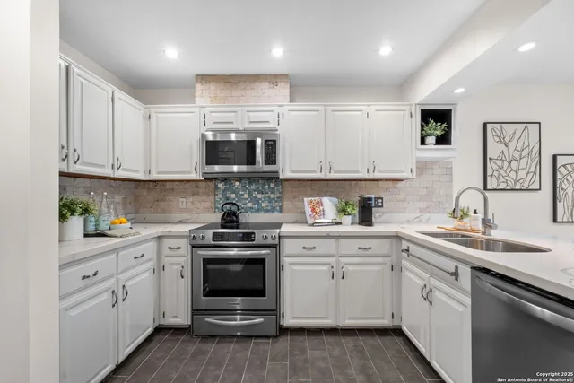 a kitchen with stainless steel appliances granite countertop a sink and cabinets with wooden floors