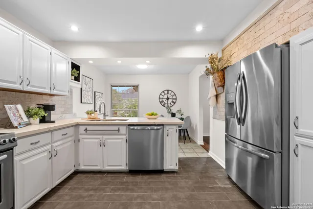 a kitchen with stainless steel appliances a refrigerator sink and cabinets