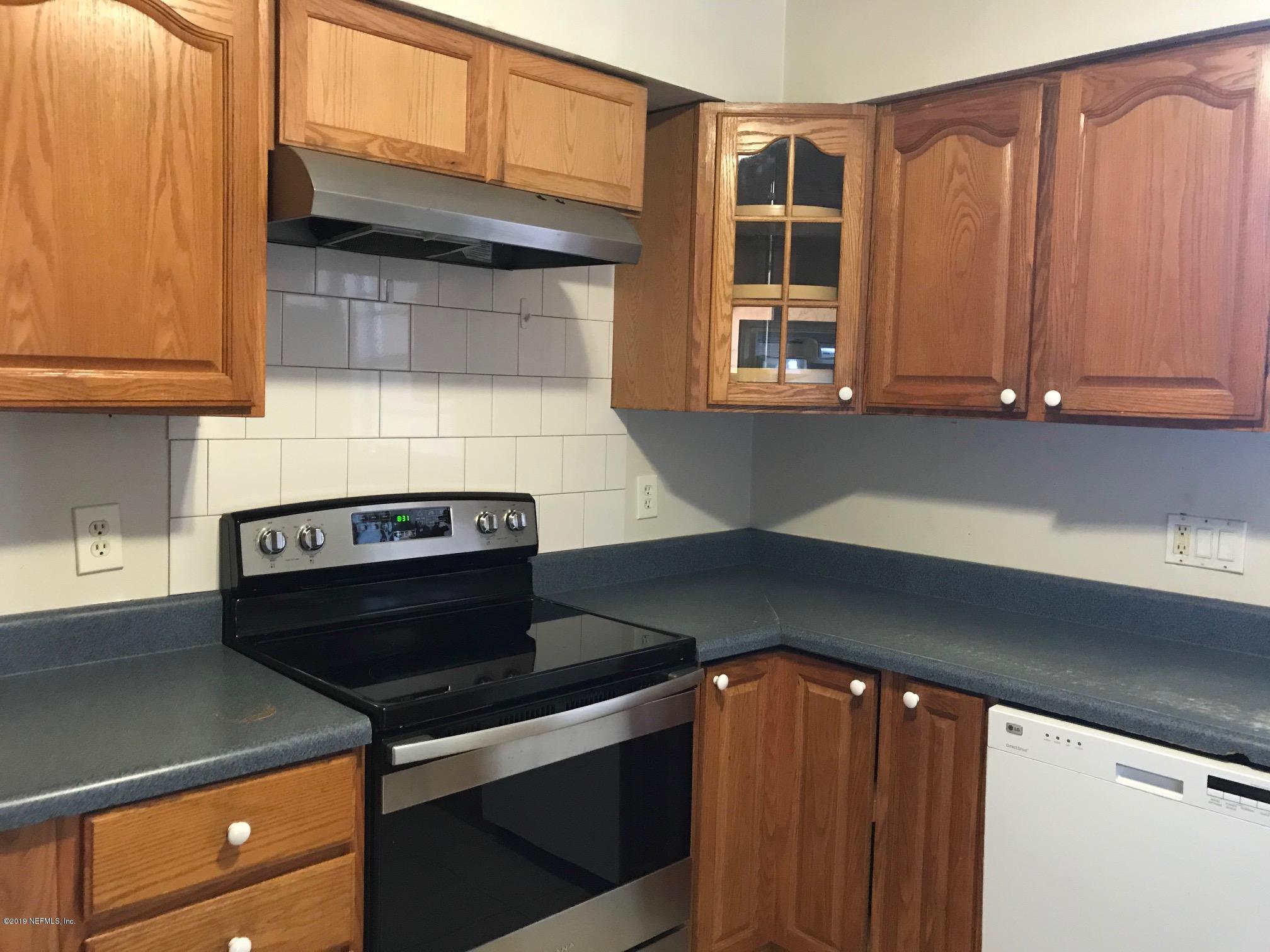 111 Cypress Road St. Augustine, FL 32086 - Photo 5 of 10 a kitchen with wooden cabinets and a stove top oven