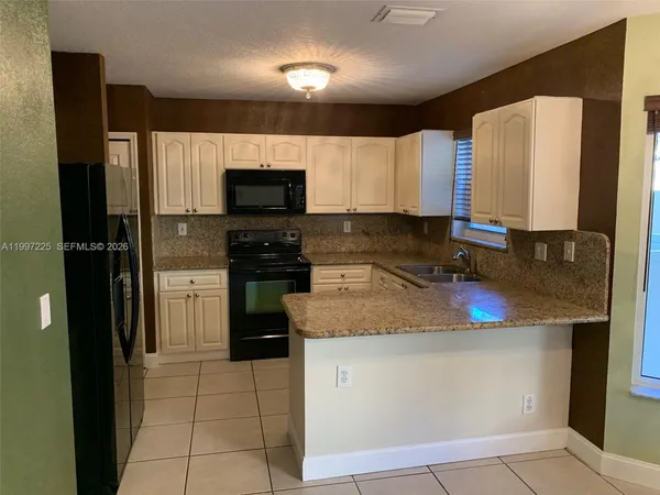 a kitchen with stainless steel appliances granite countertop a refrigerator and a stove