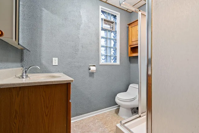 a bathroom with a sink a toilet and a window