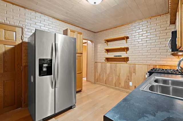 a kitchen with stainless steel appliances granite countertop a refrigerator and a stove