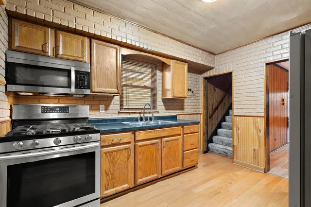 a kitchen with stainless steel appliances a stove sink and microwave