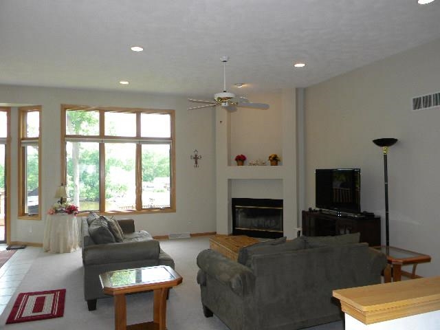 10727 Chicory Ridge Way Roscoe, IL 61073 - Photo 3 of 23 a living room with furniture flat screen tv and a fireplace