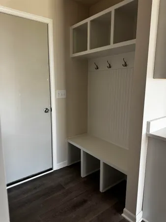 a view of an empty room with wooden floor and cabinet