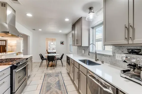 a kitchen with stainless steel appliances a sink stove and cabinets