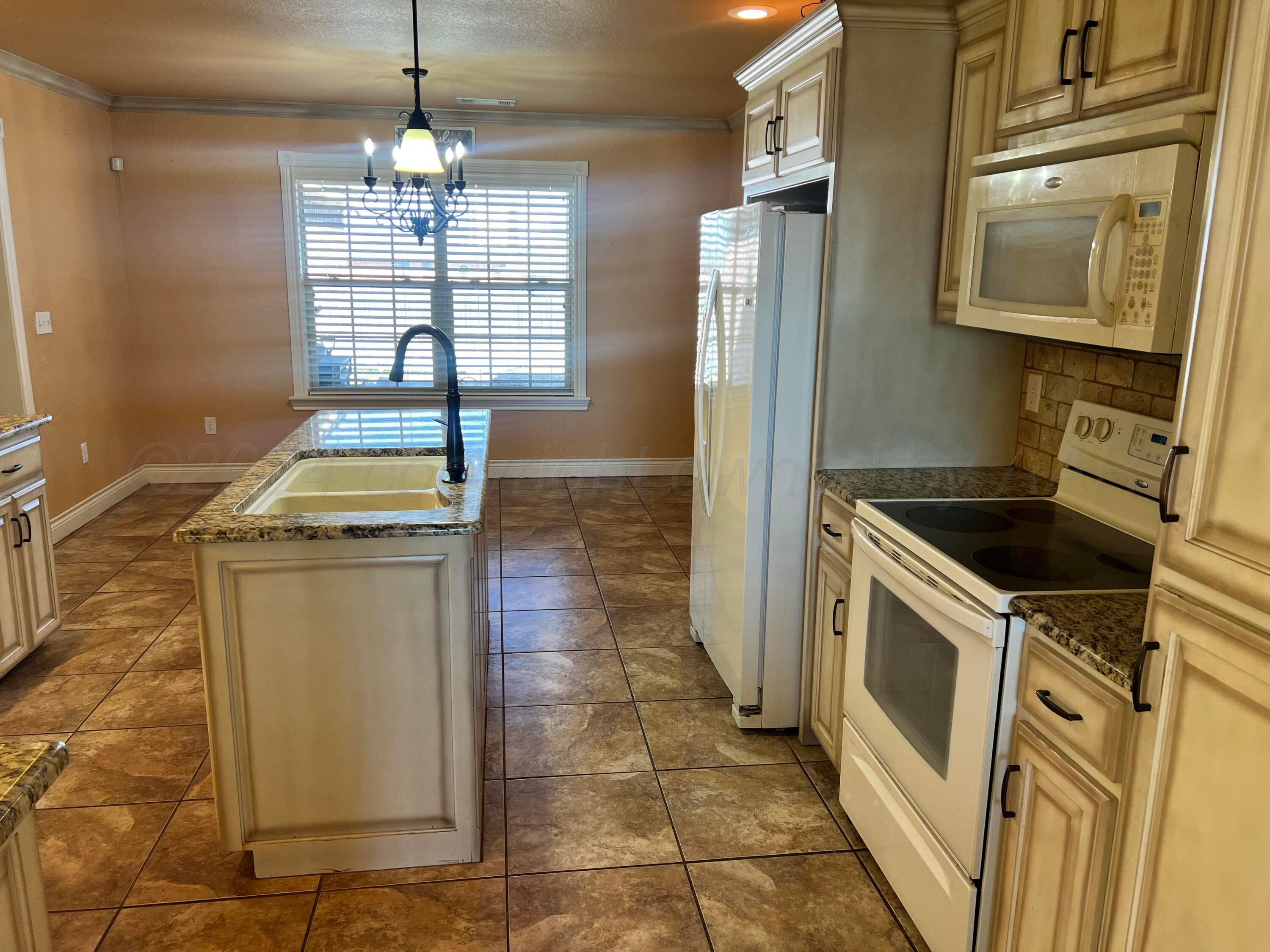 830 Baltimore Drive Hereford, TX 79045 - Photo 11 of 46 a kitchen with stainless steel appliances granite countertop a stove a sink and a refrigerator