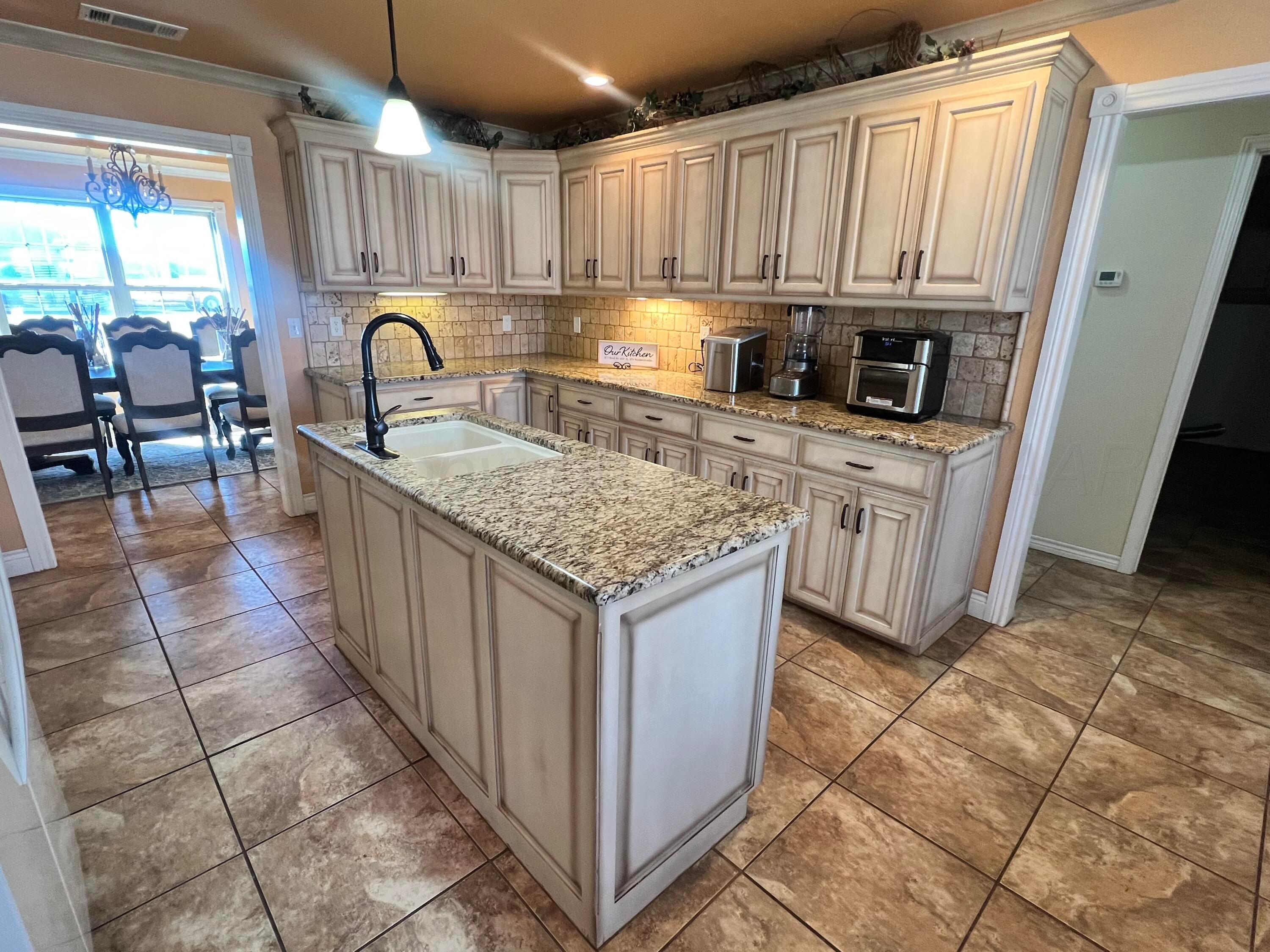 830 Baltimore Drive Hereford, TX 79045 - Photo 12 of 46 a kitchen with stainless steel appliances granite countertop a table chairs sink and cabinets