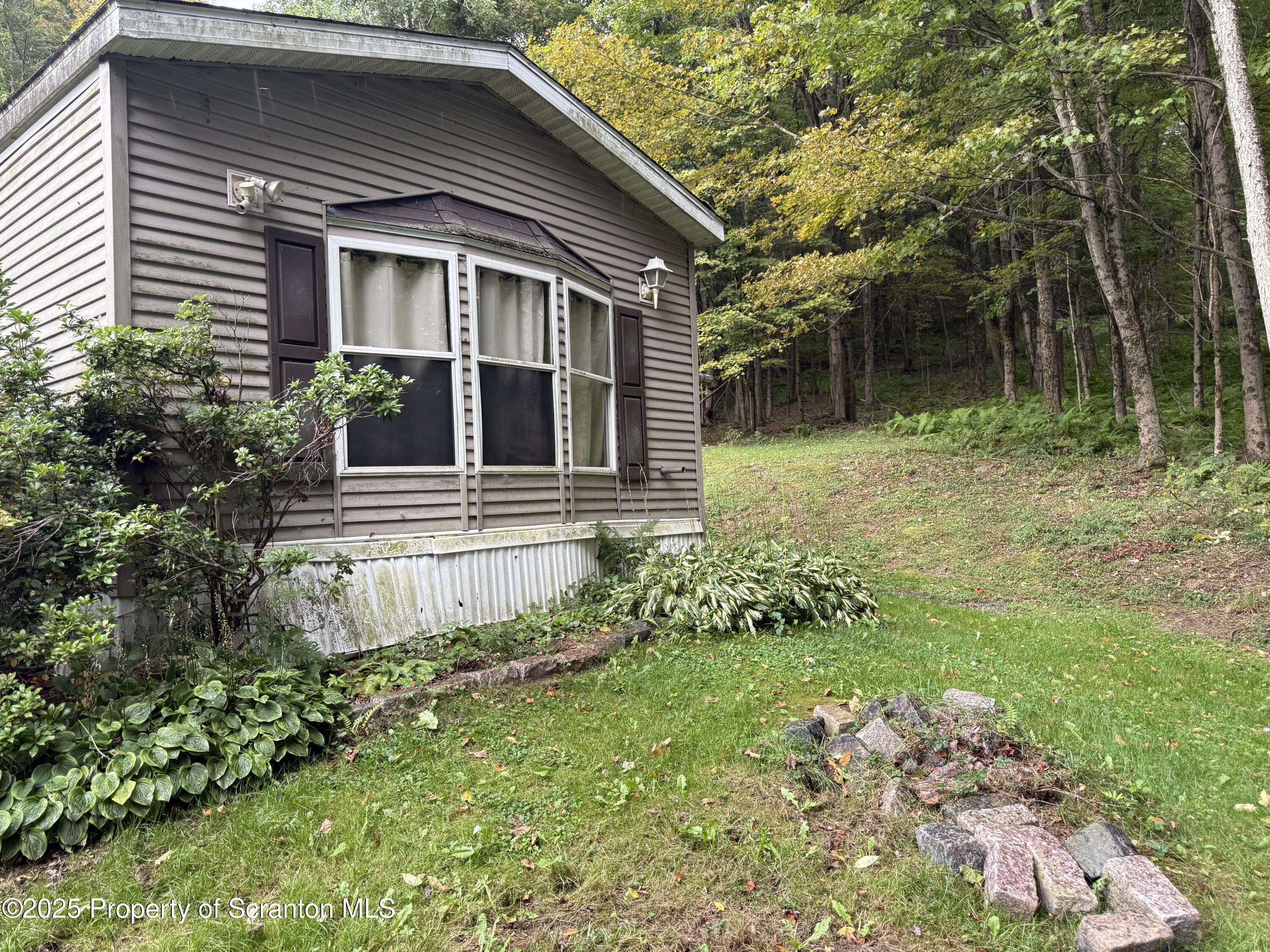 1218 Campsite Road Thompson, PA 18465 - Photo 24 of 26 front view of house with a yard