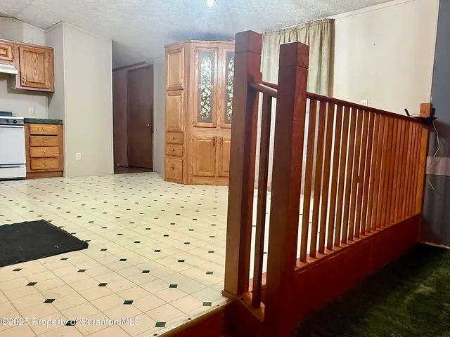 a view of a hallway with wooden floor and cabinet