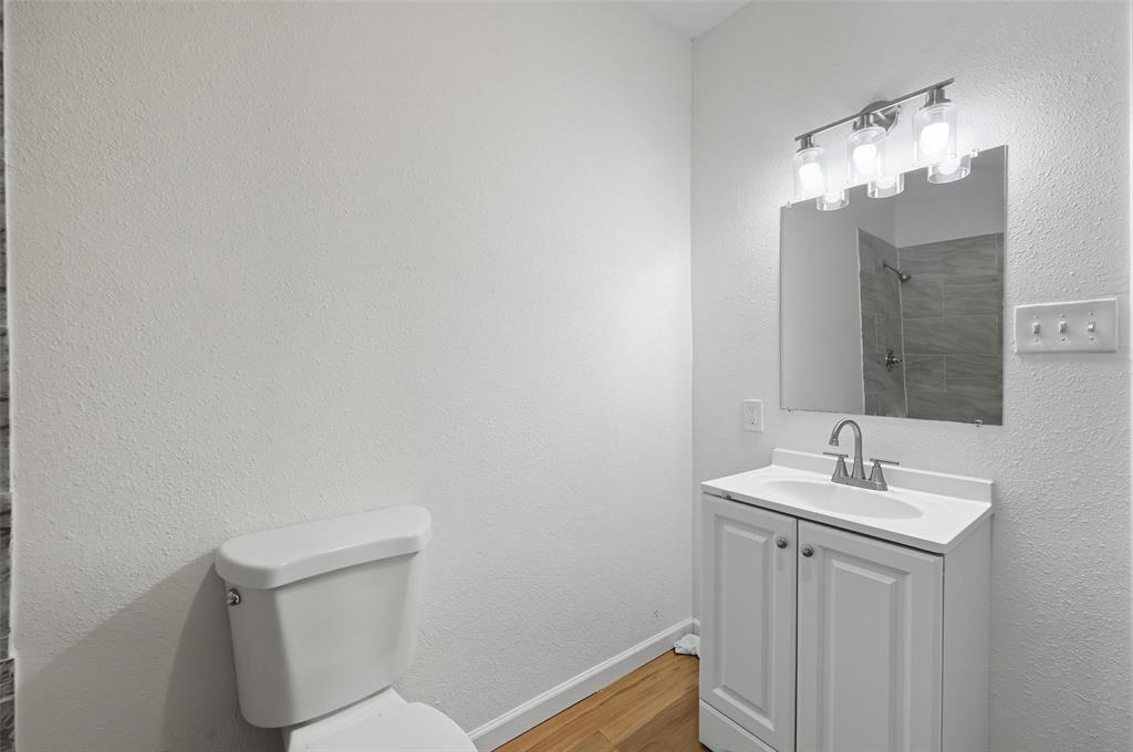 809 North Maxey Street Sherman, TX 75090 - Photo 14 of 19 a bathroom with a toilet sink and mirror