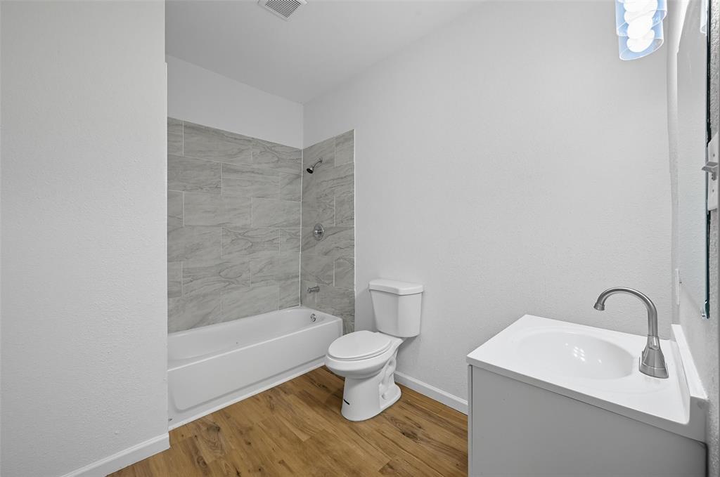 809 North Maxey Street Sherman, TX 75090 - Photo 15 of 19 a bathroom with a toilet a sink and a bathtub