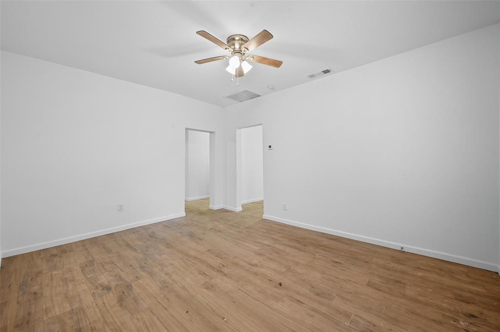 809 North Maxey Street Sherman, TX 75090 - Photo 7 of 19 a view of an empty room with chandelier fan and wooden floor