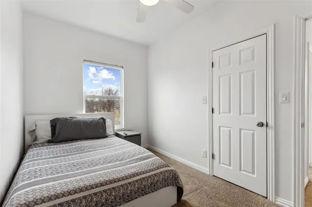 a bedroom with a bed and painting on the wall