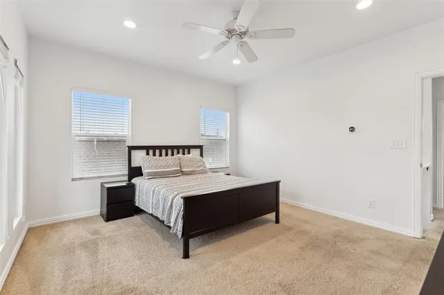 a spacious bedroom with a large bed and a chandelier