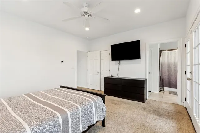 a spacious bedroom with a bed and a flat screen tv