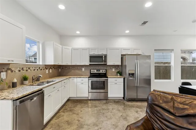 a kitchen with a refrigerator sink and cabinets