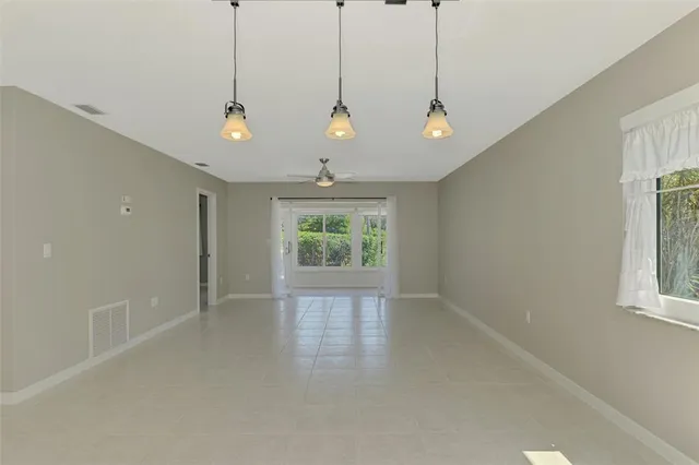 an empty room with a window and a ceiling fan