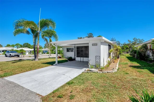 a view of a house with backyard and a tree
