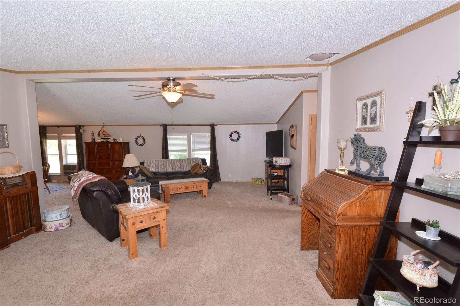 30640 Aldred Road Pueblo, CO 81006 - Photo 16 of 34 a living room with furniture and a flat screen tv