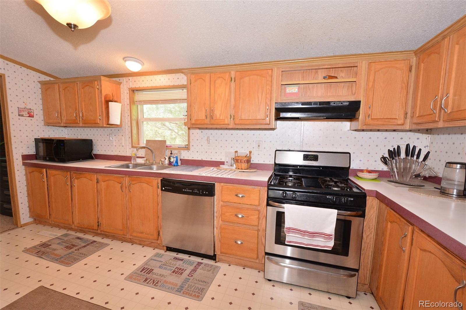30640 Aldred Road Pueblo, CO 81006 - Photo 22 of 34 a kitchen with stainless steel appliances granite countertop a stove a sink and a microwave