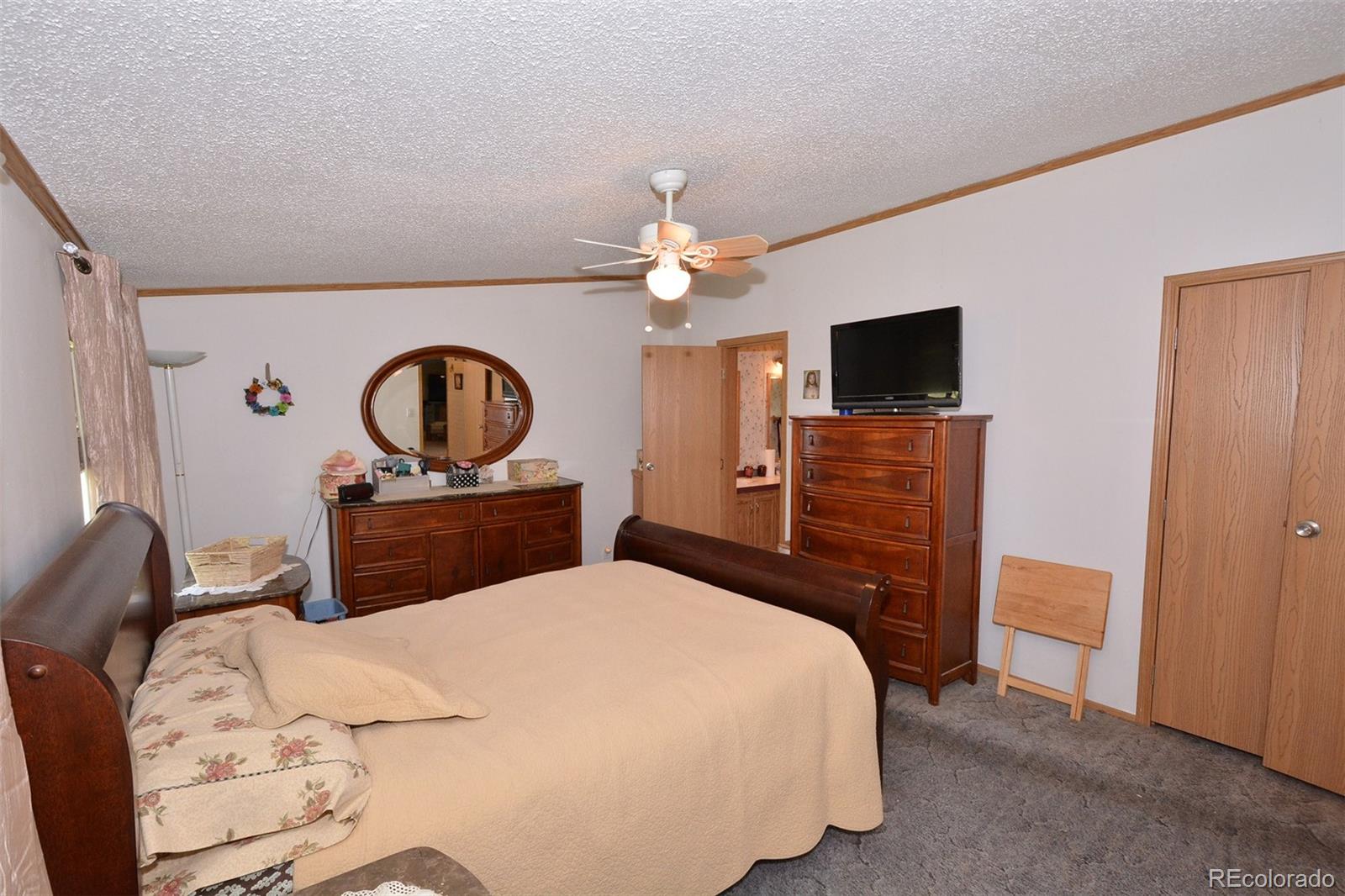 30640 Aldred Road Pueblo, CO 81006 - Photo 25 of 34 a bedroom with a bed and a flat tv screen on dresser
