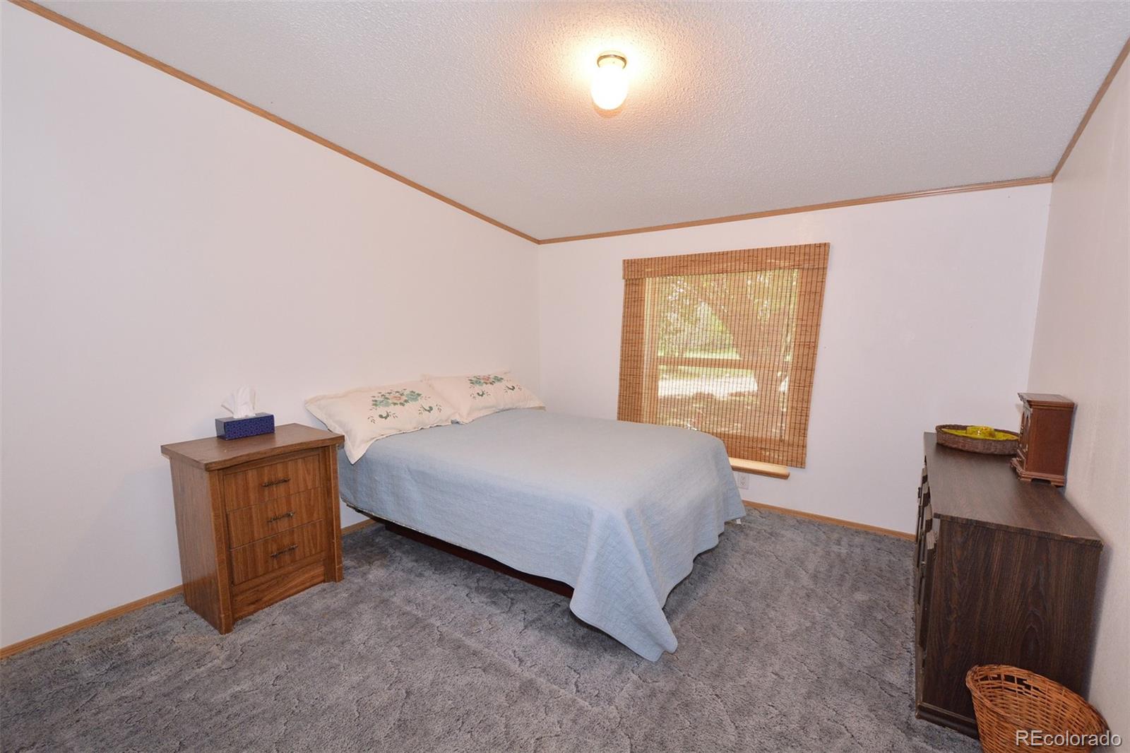 30640 Aldred Road Pueblo, CO 81006 - Photo 30 of 34 a bedroom with a bed and wooden floor
