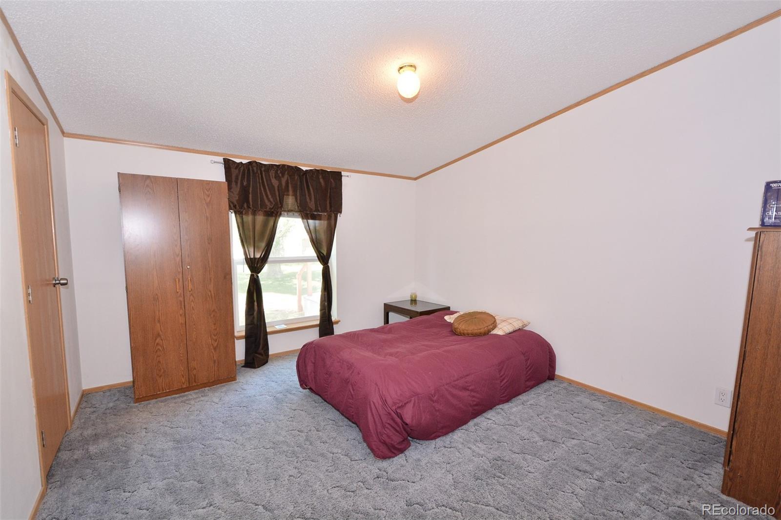 30640 Aldred Road Pueblo, CO 81006 - Photo 31 of 34 a bedroom with a bed and a window