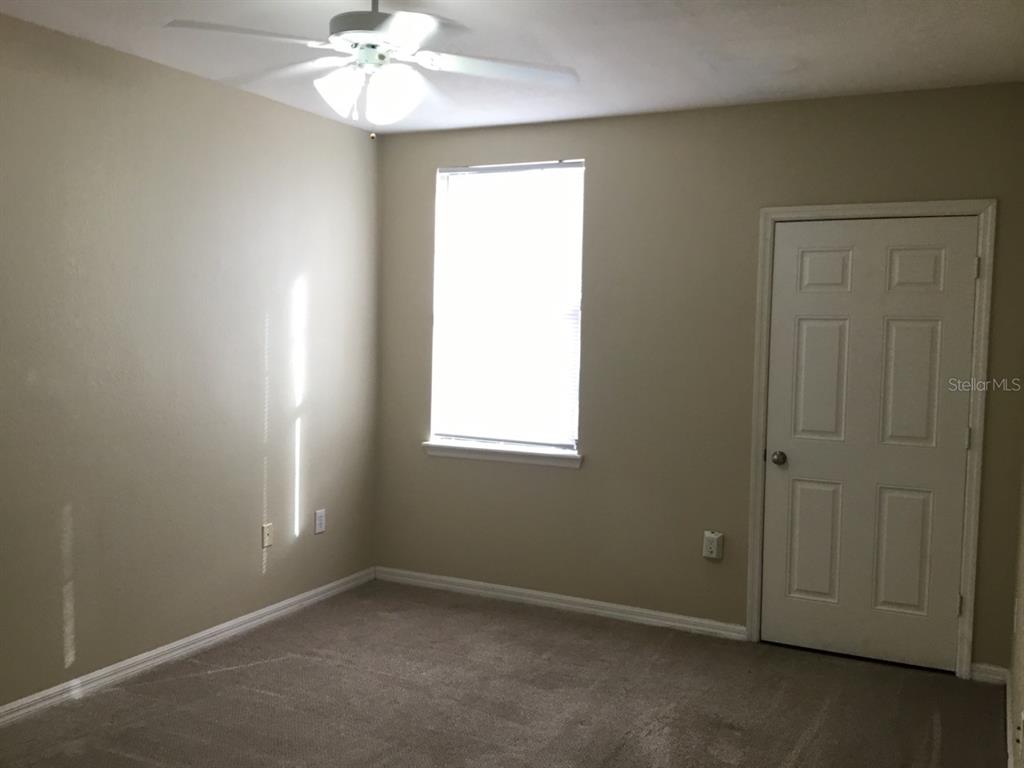 5550 East Michigan Street, Unit 3232 Orlando, FL 32822 - Photo 15 of 21 an empty room with a window and a chandelier fan