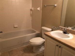 5550 East Michigan Street, Unit 3232 Orlando, FL 32822 - Photo 18 of 21 a bathroom with a sink toilet and shower