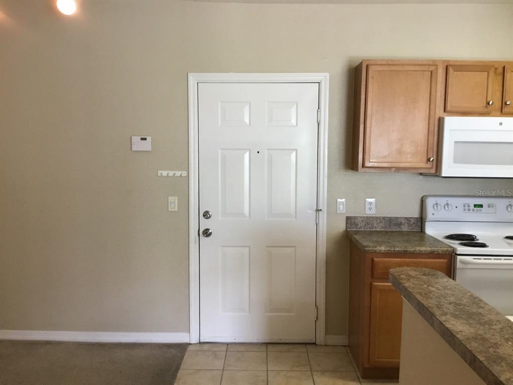 5550 East Michigan Street, Unit 3232 Orlando, FL 32822 - Photo 7 of 21 a kitchen with a stove and a refrigerator