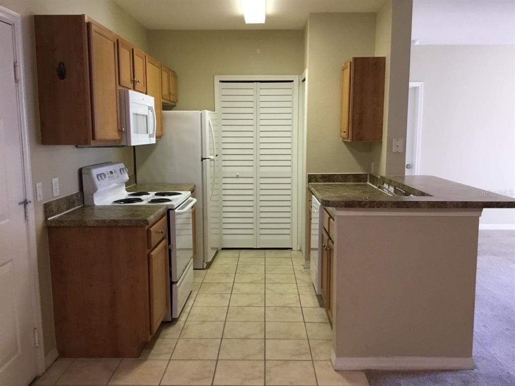 5550 East Michigan Street, Unit 3232 Orlando, FL 32822 - Photo 8 of 21 a kitchen with stainless steel appliances granite countertop a stove a sink and a refrigerator