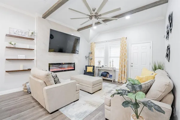 a living room with furniture a flat screen tv and a fireplace