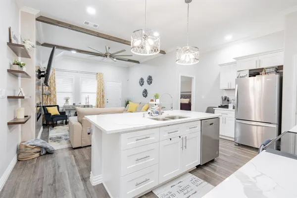 a kitchen with a white cabinets and chandelier