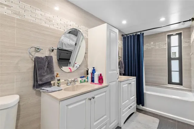 a bathroom with a double vanity sink mirror and toilet