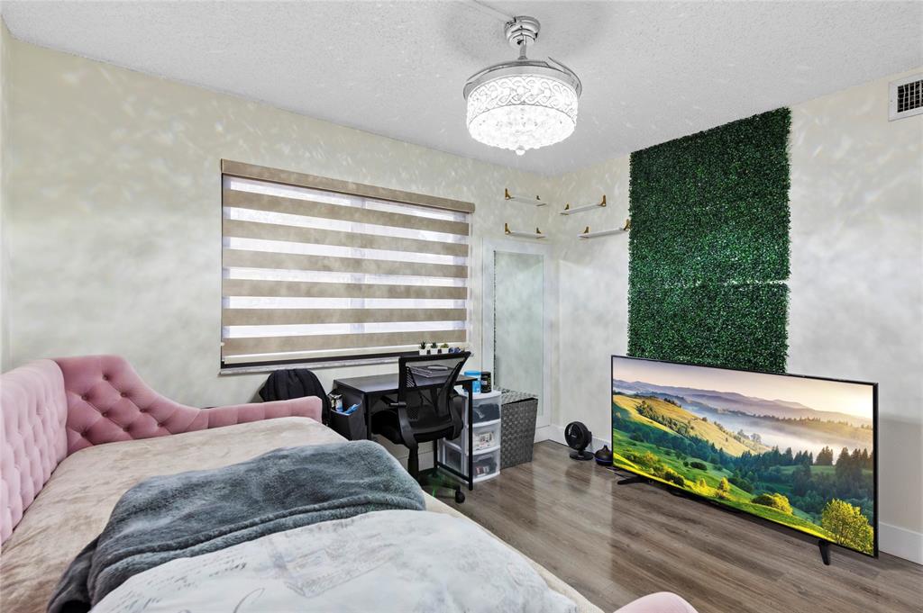 9300 Southwest 8th Street, Unit 102 Boca Raton, FL 33428 - Photo 15 of 23 a bed sitting in a bedroom next to a window