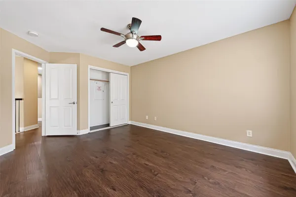 a view of a big room with wooden floor and windows