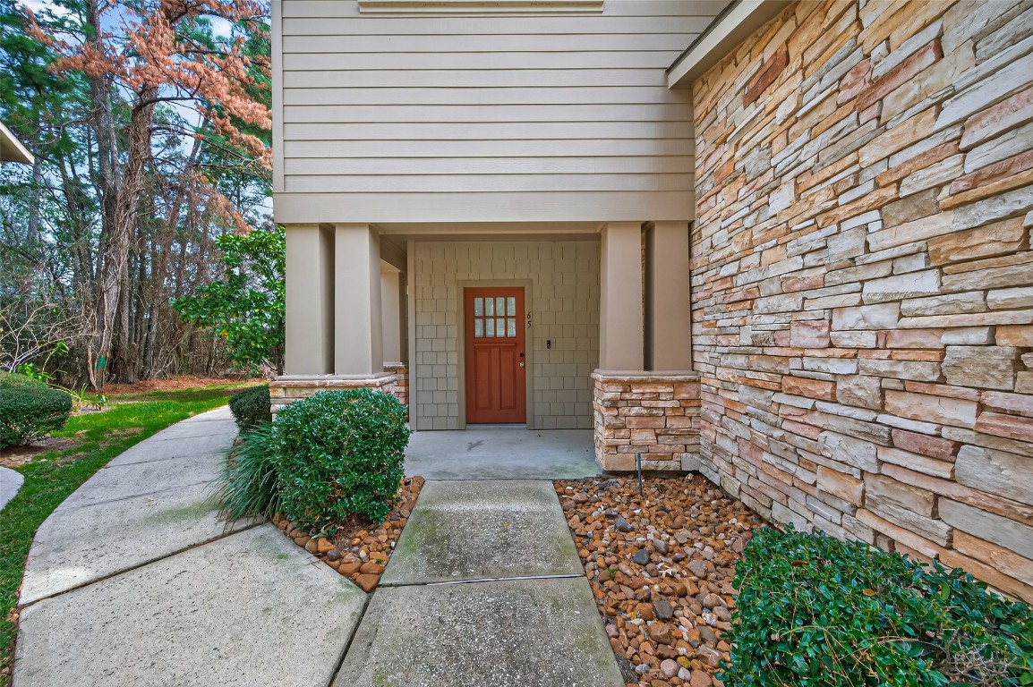 65 Scarlet Woods Court Spring, TX 77380 - Photo 2 of 36 Welcoming front entrance with tidy landscaping featuring bushes and a paved walkway.