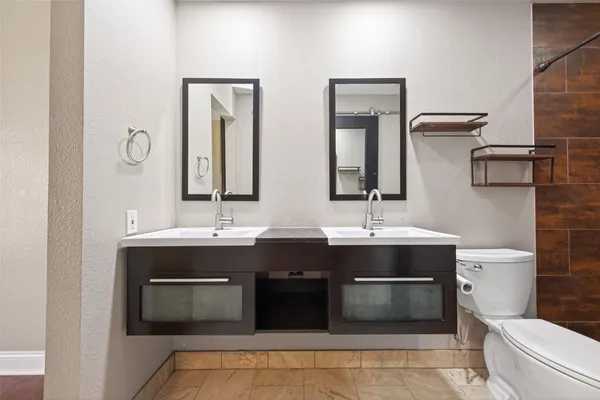 a bathroom with a sink a toilet a mirror and shower
