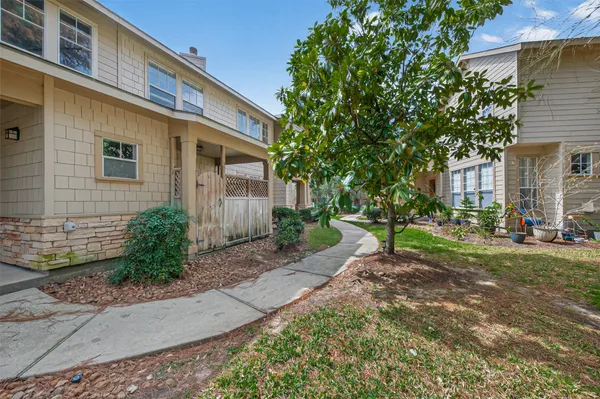 a front view of a house with a yard and potted plants