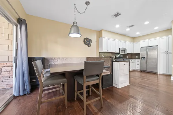a kitchen with a table chairs refrigerator and microwave