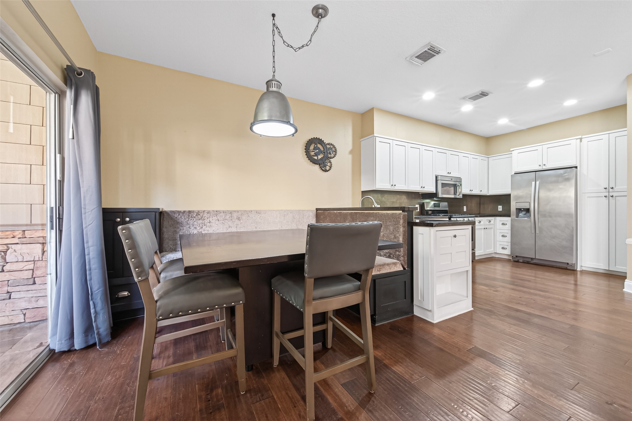 65 Scarlet Woods Court Spring, TX 77380 - Photo 7 of 36 a kitchen with stainless steel appliances kitchen island granite countertop a table chairs a sink and a refrigerator